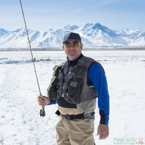 Pescatore con canna da pesca con paesaggio innevato
